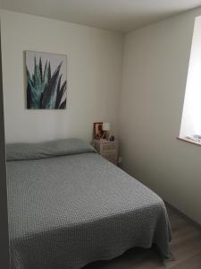 a bedroom with a bed and a painting on the wall at Maisonnette Montferrandaise proche Tram - 6 couchages - tram - wifi in Clermont-Ferrand