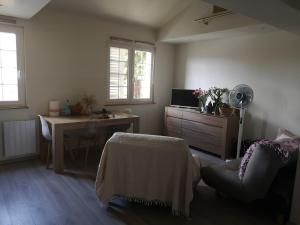 a living room with a desk and a chair and a fan at Maisonnette Montferrandaise proche Tram - 6 couchages - tram - wifi in Clermont-Ferrand +5 photos