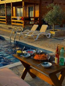 a table with food on it next to a swimming pool at Bungalovi Spahic in Ulcinj