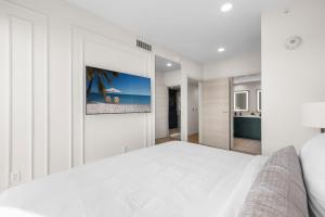 a white bedroom with a large white bed and a bathroom at The Avenue Coral Gables in Miami +55 photos