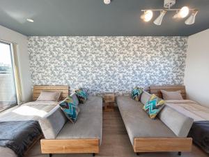 a bedroom with two beds and a wall with wallpaper at THE POOL HOUSE Kisarazu in Kisarazu