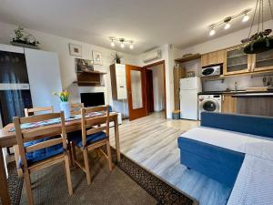 a kitchen and living room with a table and a couch at Germar Apartman in Pécs
