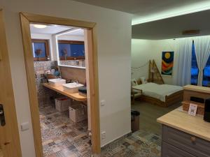 a bathroom with two sinks and a bedroom with a bed at Dům mezi loukami in Sněžné