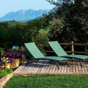 two green chairs sitting on a wooden deck with a view at Casatona in San Mateo de Bages +3 photos