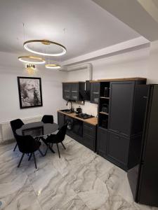 a kitchen with black cabinets and a table and chairs at Villa Garden in Drobeta-Turnu Severin