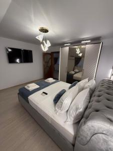 a bedroom with a large bed and a television at Villa Garden in Drobeta-Turnu Severin