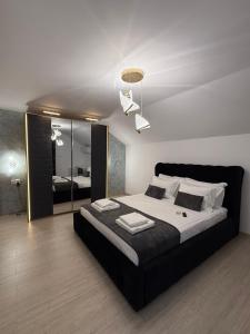 a bedroom with a large bed and a mirror at Villa Garden in Drobeta-Turnu Severin