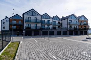 a row of buildings in a parking lot at Łeba Garden Apartament in Łeba
