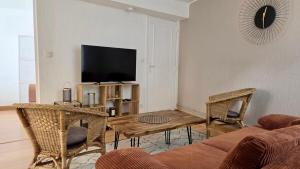 a living room with a couch and a table and a tv at Le Saint Jacques - Downtown in Melun