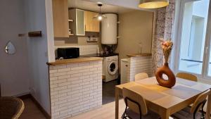 a kitchen with a table with a vase on it at Le Saint Jacques - Downtown in Melun