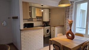 a kitchen with a table with a vase on it at Le Saint Jacques - Downtown in Melun +2 photos