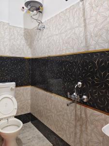 a bathroom with a toilet and black and white tiles at Sri Ram Shankar-Saryu Ghat in Ayodhya