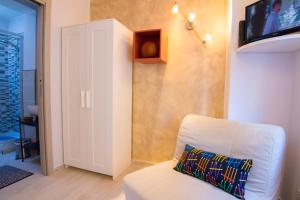 a living room with a white couch and a tv at Rosemary Charming Rooms in Termoli