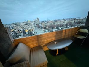 a room with a bench and a window with a view at Kara Apartaments in Ploieşti
