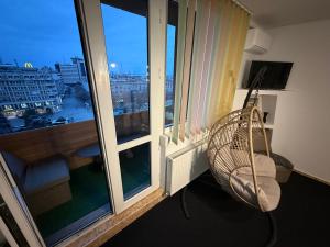 a room with a balcony with a view of a city at Kara Apartaments in Ploieşti