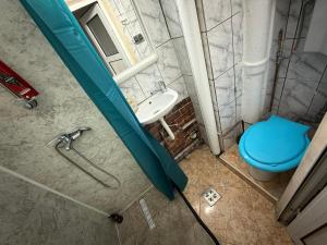a bathroom with a blue toilet and a sink at Kara Apartaments in Ploieşti