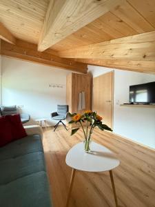 a living room with a vase of flowers on a table at Haus Lagger in Seefeld in Tirol +18 photos