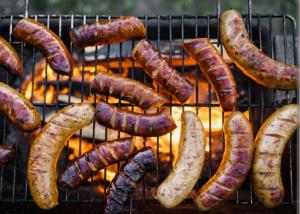 a bunch of sausages cooking on a grill at Villa Maximos in Episkopí