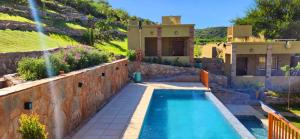 a house with a swimming pool in a yard at Las Cabras Complejo Turístico in Potrero de los Funes