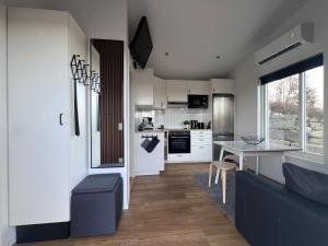 a kitchen and living room with a table and a dining room at The Fäxaåsen cabin in Varberg