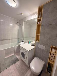 a bathroom with a washing machine and a toilet at Sloth Room in Warsaw