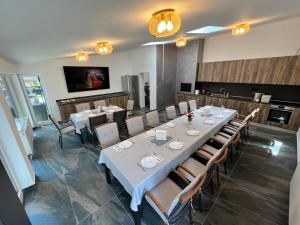 a dining room with a long table and chairs at Green Wood in Azuga