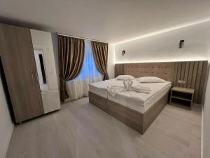 a bedroom with a bed and a large window at Green Wood in Azuga