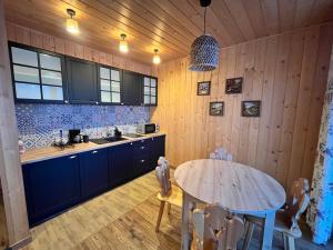a kitchen with wooden walls and a wooden table at Domki Baby Jagi in Krajno Pierwsze
