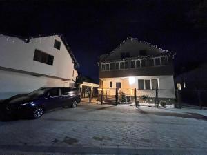 a car parked in front of a building at night at Green Wood in Azuga