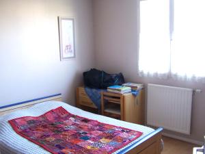 a bedroom with a bed and a desk and a window at Chambre lit double in Saint-Herblain
