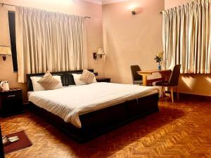 a bedroom with a bed and a table and chairs at Rinchen Hotel in Kathmandu