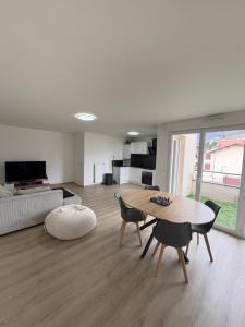 a living room with a table and chairs and a couch at Appartement T2 Confort in Albertville