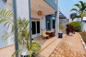 a patio with a table and chairs on a house at One Click Cozy Suites in Kigali