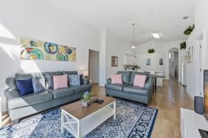 a living room with two couches and a table at 4 BR No carpet Just Remodeled Unit SR1205 in Kissimmee +39 photos