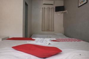 a bedroom with two beds with red and white sheets at Mutary II in Santa Cruz Cabrália