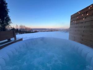 a jacuzzi tub with snow on the ground at Domki Baby Jagi in Krajno Pierwsze