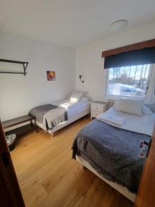 a bedroom with two beds and a window at Spói Guesthouse in Hvolsvöllur