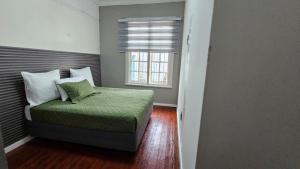 a small bedroom with a bed with a window at Jacaranda Escape in Pretoria