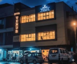 a building with cars parked in front of it at Hotel Venus in Jabalpur