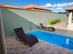 a patio with two chairs and a swimming pool at Casas Bela Vista 1 - 2 in Águas de Lindoia