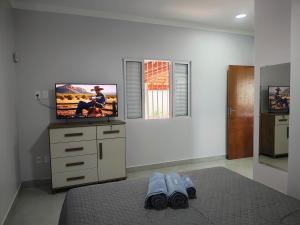 a bedroom with a flat screen tv and a bed at Casas Bela Vista 1 - 2 in Águas de Lindoia