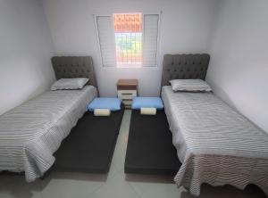 two twin beds in a room with a window at Casas Bela Vista 1 - 2 in Águas de Lindoia +51 photos