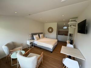 a bedroom with a bed and a desk and chairs at B&B Roodbeekerhof in Vlodrop