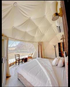 a bedroom with a tent with a table and chairs at Camp in Wadi Rum in Maḩaţţat Dīsah
