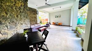 a living room with a table and a stone wall at Humble Ella in Ella