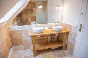 a bathroom with two sinks on a wooden table at La Suite de Richarville in Richarville +19 photos