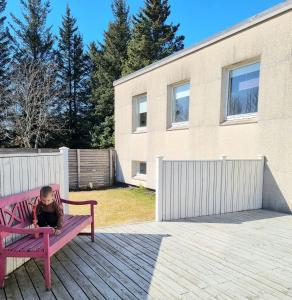 a little girl sitting on a pink bench at Spói Guesthouse in Hvolsvöllur +38 photos