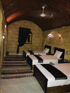 a room with four beds in a room with a ceiling at Labib Guest house in Aswan
