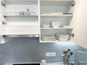 a kitchen with white cabinets and white plates at Ruhiger Familientraum fürs Wochenende oder längerfristigen Aufenthalt in Wiener Neustadt +15 photos