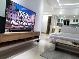 a living room with a tv and a white couch at Areito Apartament A&A in Juan López